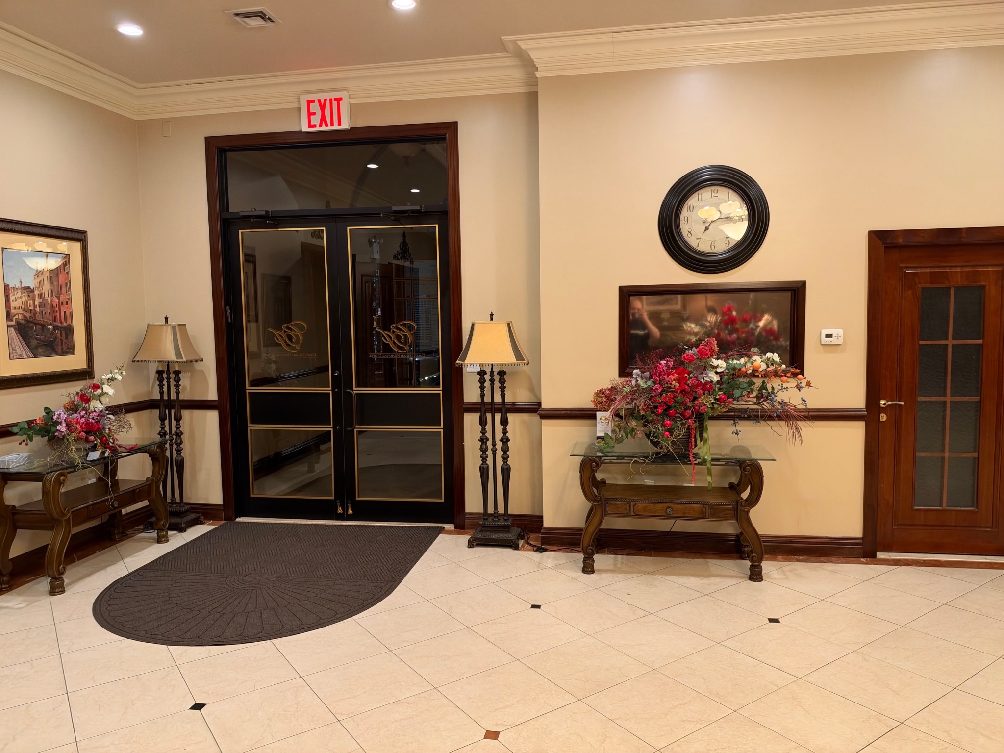 The entrance lobby with glass double doors, floral displays, and traditional furnishings.