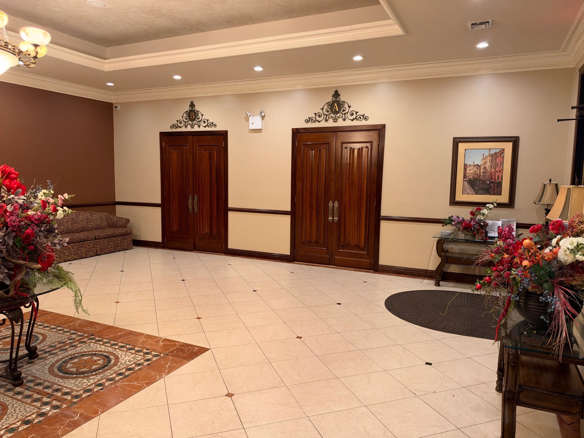 Wooden double doors leading from the tiled lobby to Chapels A and B.