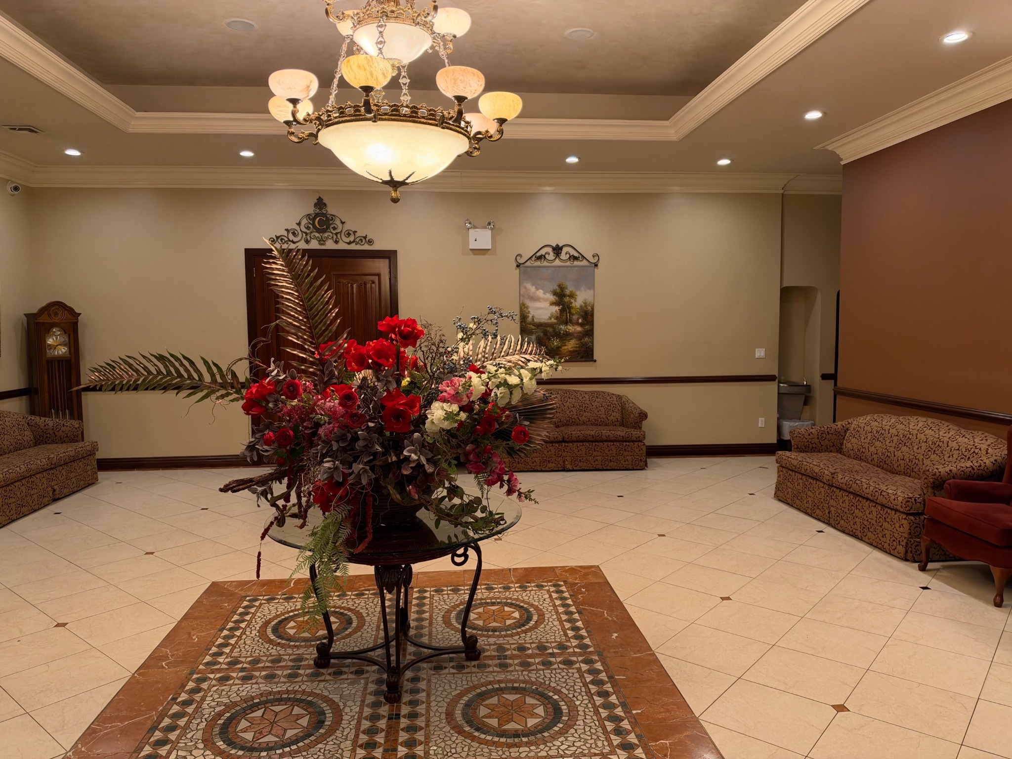 A floral centerpiece beneath the lobby chandelier, surrounded by seating for guests.
